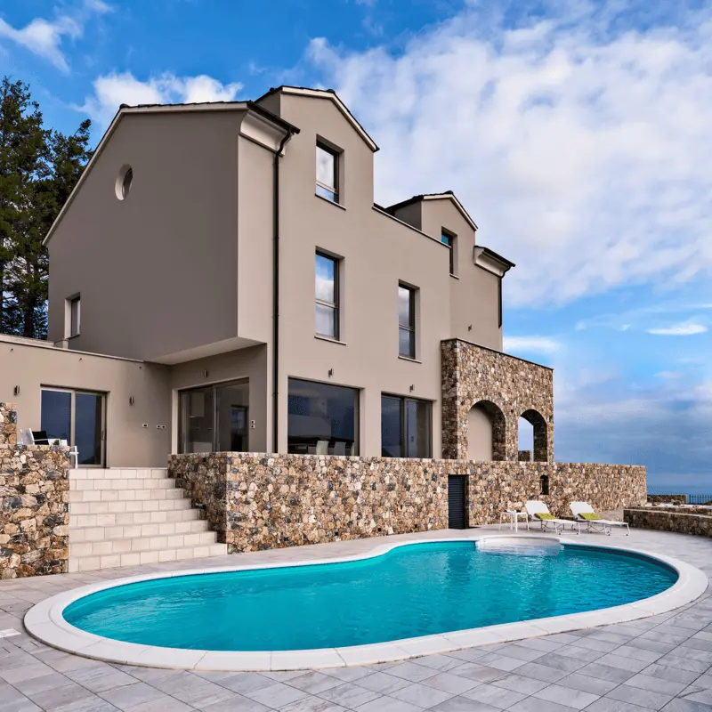 A pool built overseen by a luxurious house